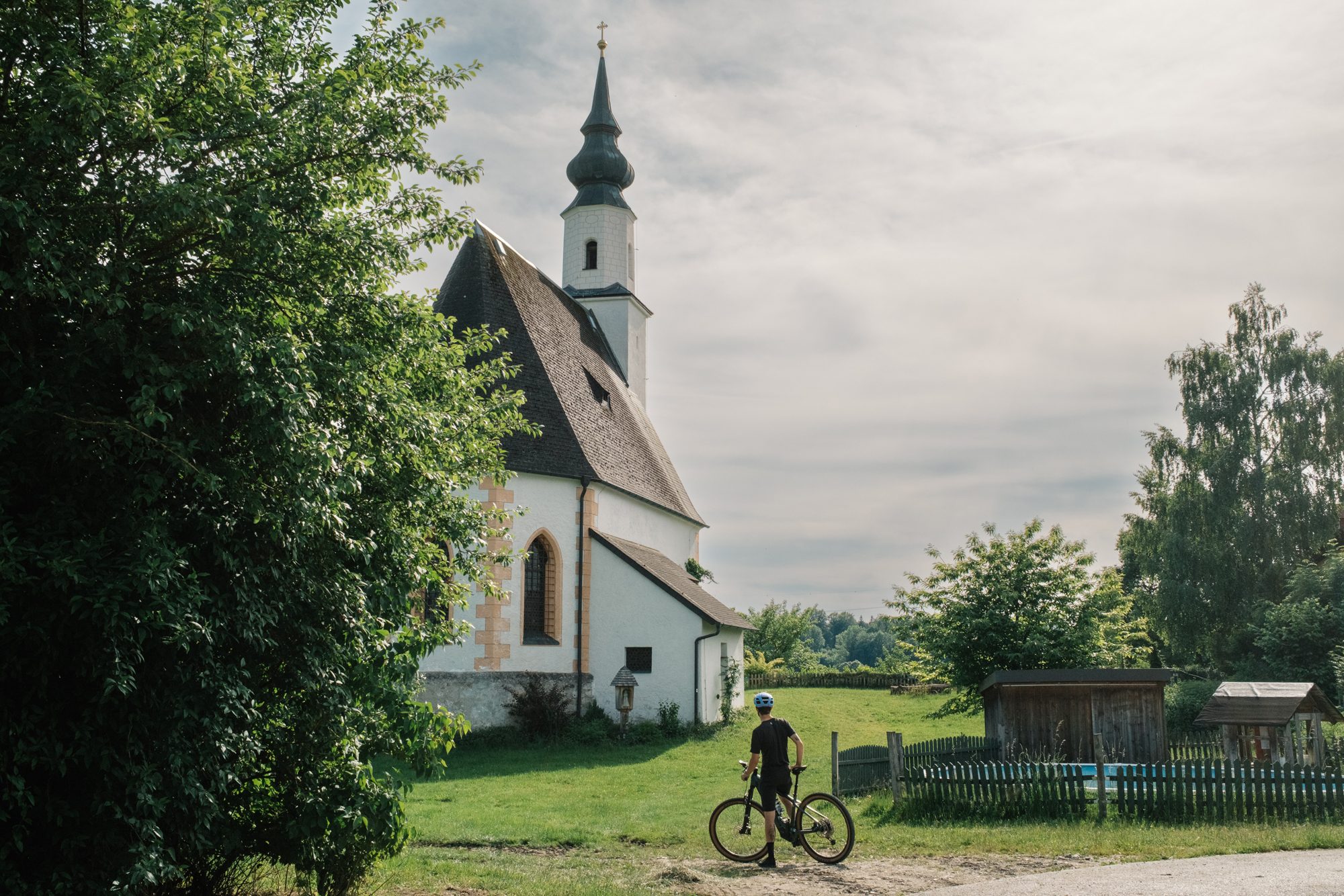 Radfahrer vor der Filialkirche Mühlbach in Eugendorf