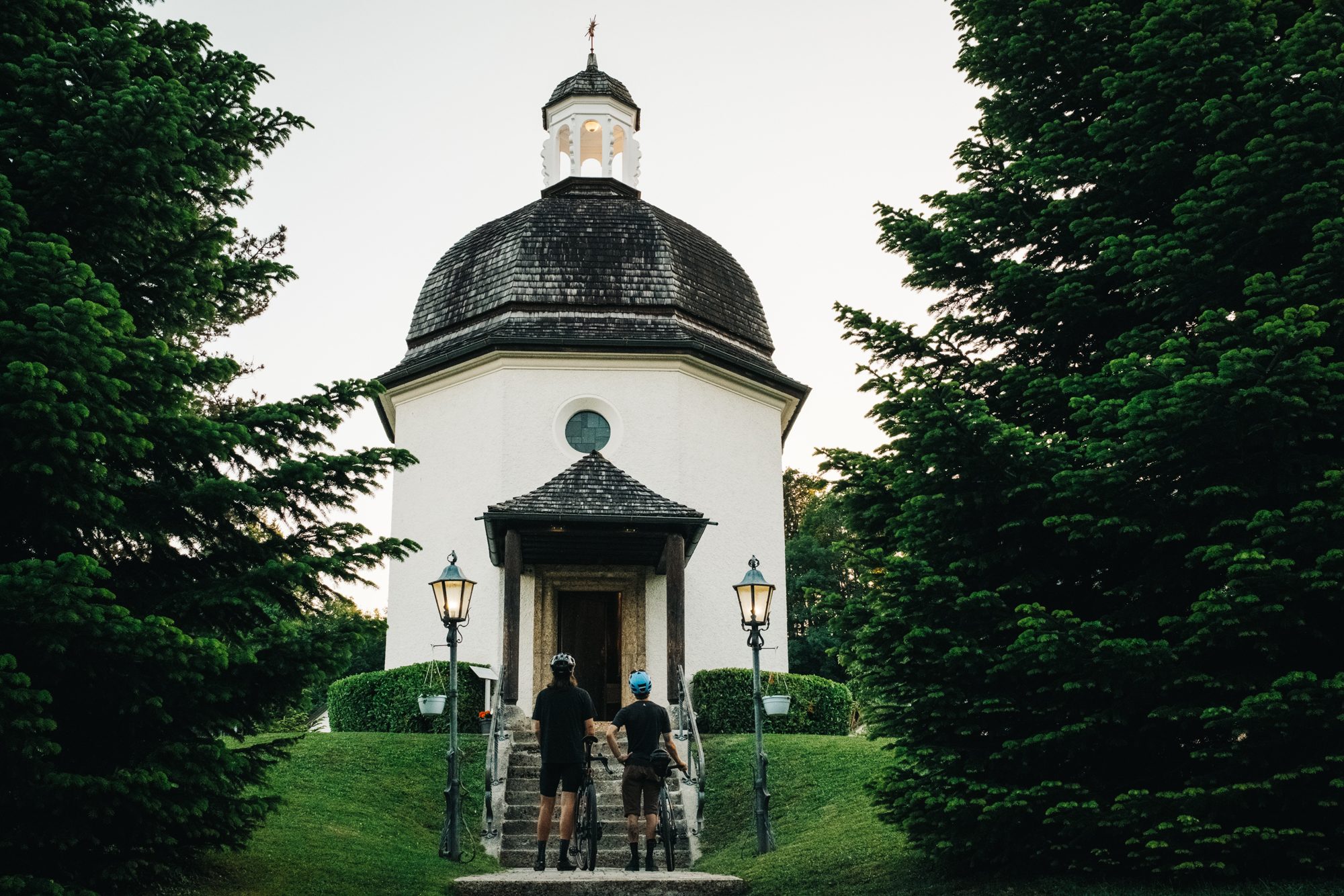 Zwei Fahrradfahrer stehen vor der Stillen Nacht Kapelle in Oberndorf